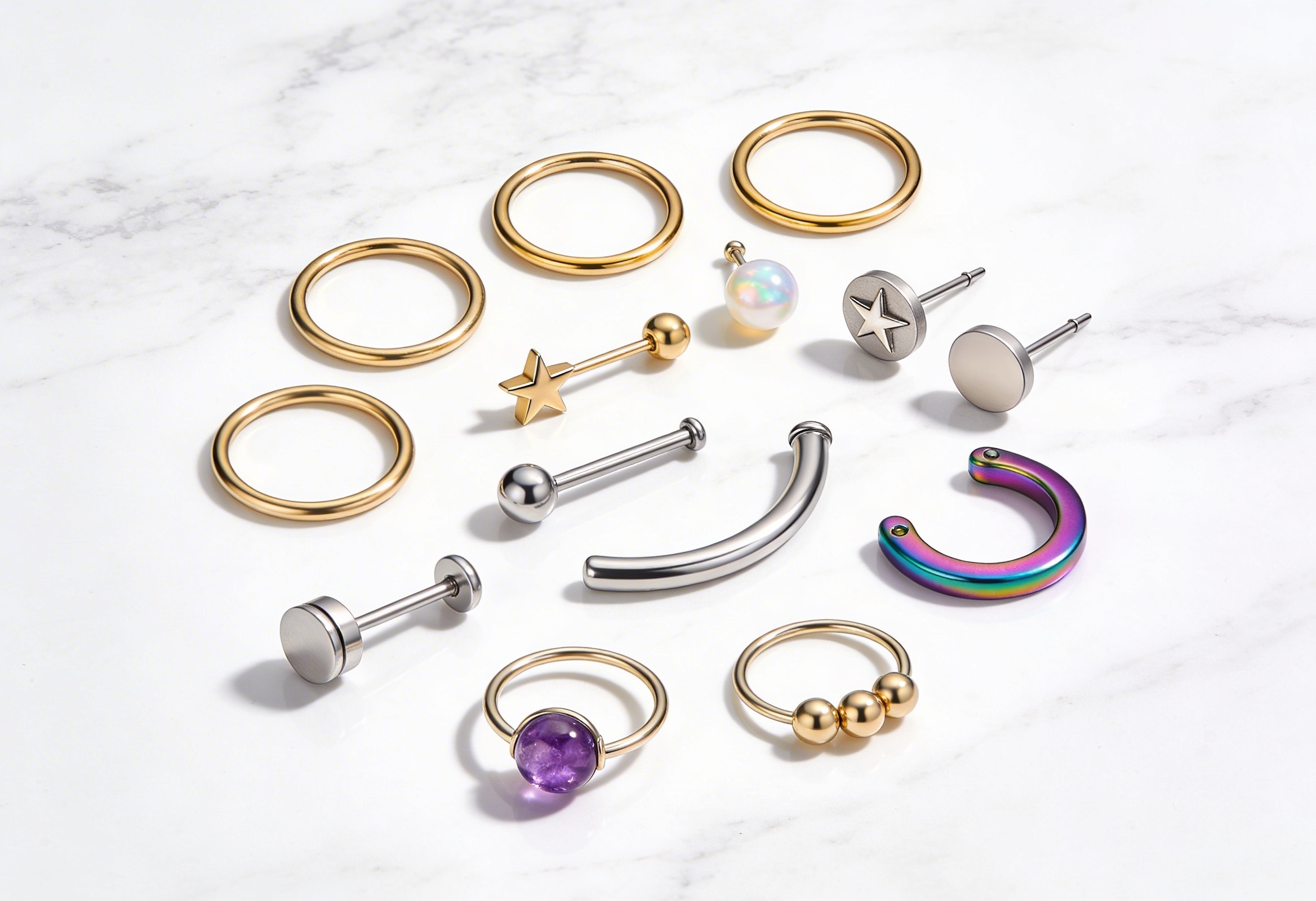 Altın ve titanyum piercing takıları düz zemin üzerinde