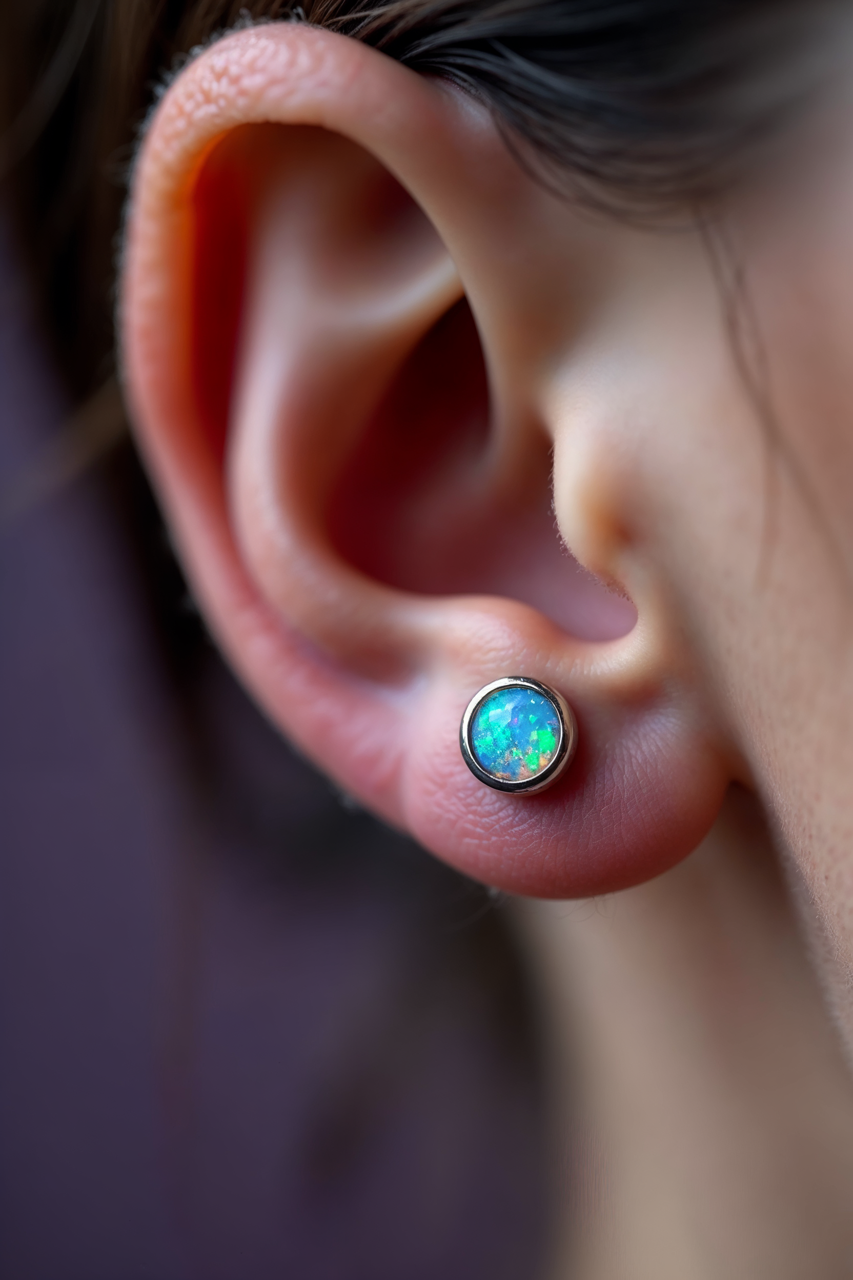 Kulak konk bölgesinde opal taşlı titanyum flatback piercing